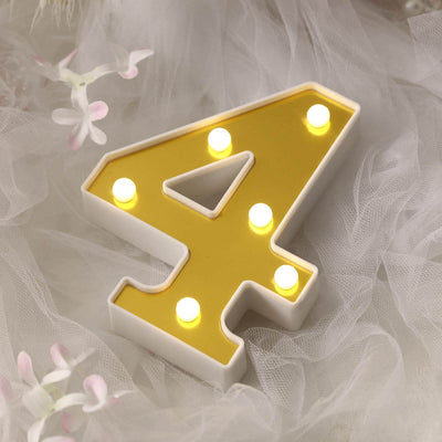Glowing letter A marquee light with soft white tulle and flowers