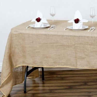 Burlap tablecloth with elegant table setting and decorative napkins.