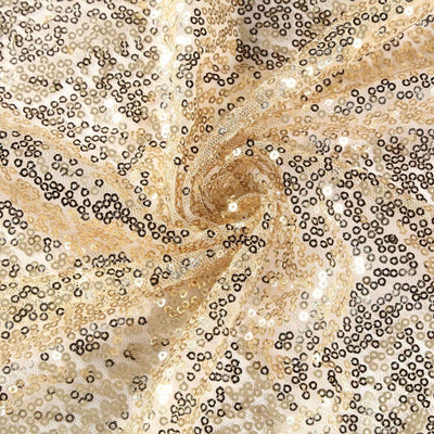 Gold and black sequin fabric in a swirling pattern.