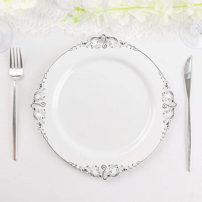 Elegant white plate with intricate silver detailing, set on a decorative table setting.