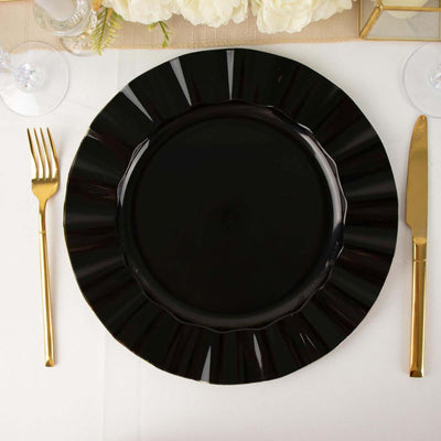 Black decorative plate with gold cutlery on a dining table setting.