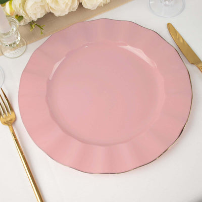Pink scalloped dinner plate with gold rim on a table setting.