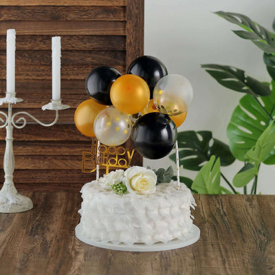 Birthday cake with black, gold, and clear balloons, decorated with a rose.