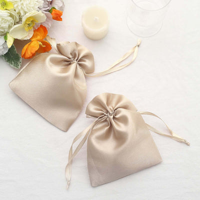 Two elegant silk drawstring bags in a soft beige color.