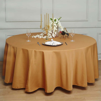Elegant round table set with gold tablecloth and decor for a refined dining experience.