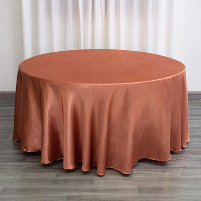 Round copper tablecloth on a wooden floor with soft draping.