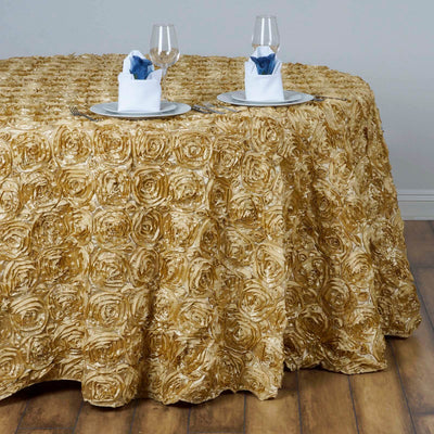Gold rose-patterned tablecloth draped over a round table with elegant dinnerware.