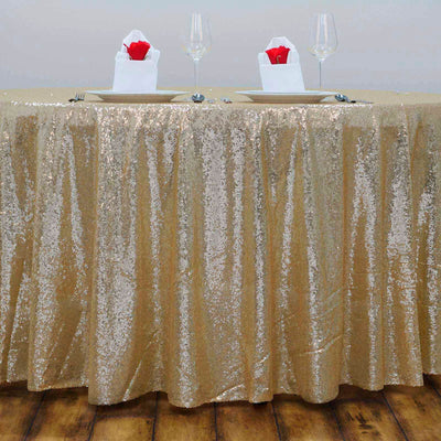 Gold sequin tablecloth draped elegantly over a table with plates and glasses.