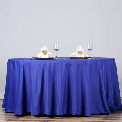 Elegant blue tablecloth with decorative napkins and glasses on a table.