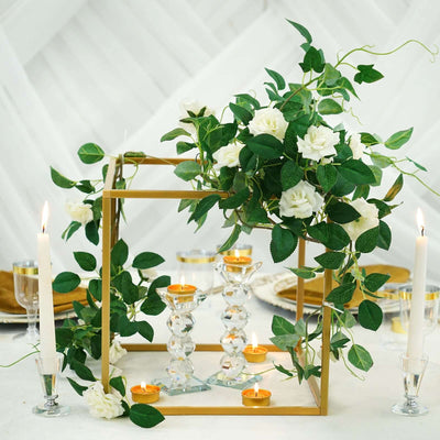 Elegant floral centerpiece with candles and greenery for table decoration.