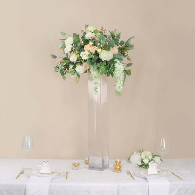 Elegant floral centerpiece in a tall glass vase for event decor.