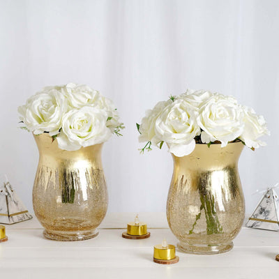 Gold vases with white roses on a decorative table