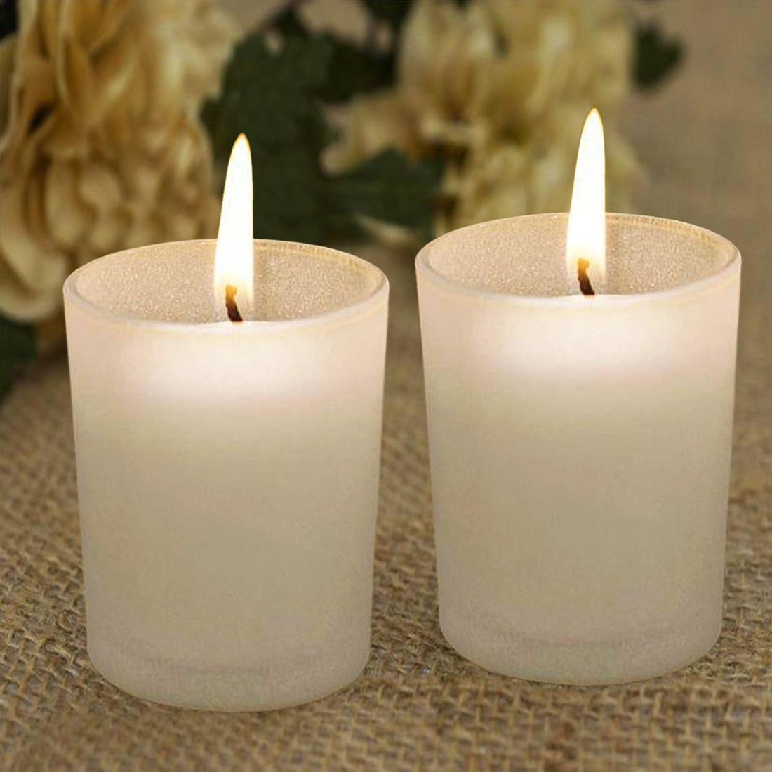 Set of two frosted glass candles with flames, perfect for ambiance.