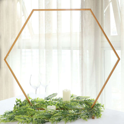Hexagon-shaped photo frame with greenery and candles on a table