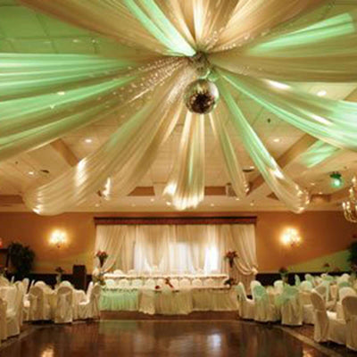 Elegant banquet hall with draped fabric and ambient lighting.