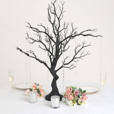 Black decorative tree centerpiece with hanging crystals and floral arrangements.