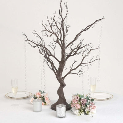 Decorative tree centerpiece with hanging crystals and floral arrangements.