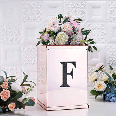 Floral arrangement in a decorative box with a letter "F" on a textured background.