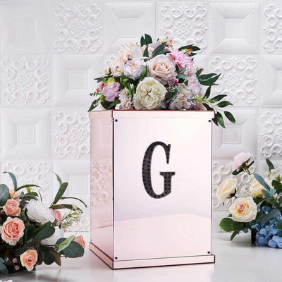 Elegant floral arrangement in a mirrored box with a letter "G" detail.