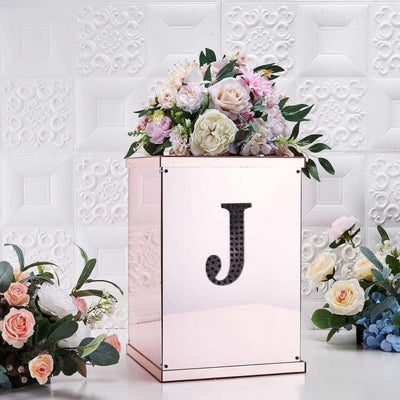 Rose gold floral display box with letter "J" and assorted flowers.