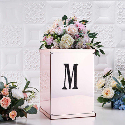 Rose gold floral arrangement box with an "M" monogram.