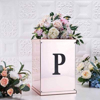 Decorative floral arrangement in a glass box with a letter "P" design.