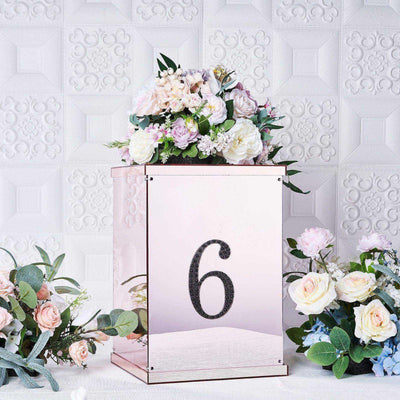 Mirrored table centerpiece with floral arrangement and number 6.