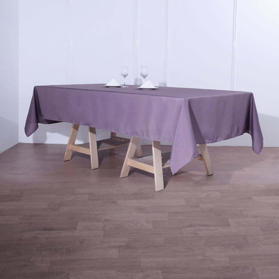 Purple tablecloth draped over a wooden table in a dining setting.