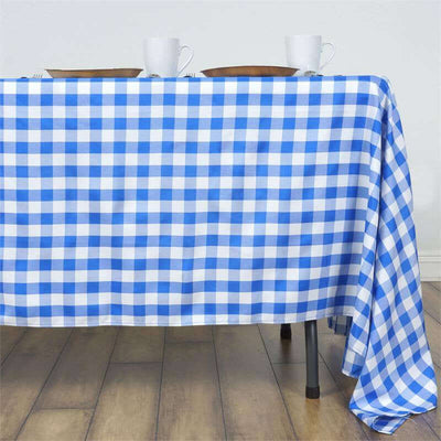 Blue and white checkered tablecloth draped over a table with dinnerware.