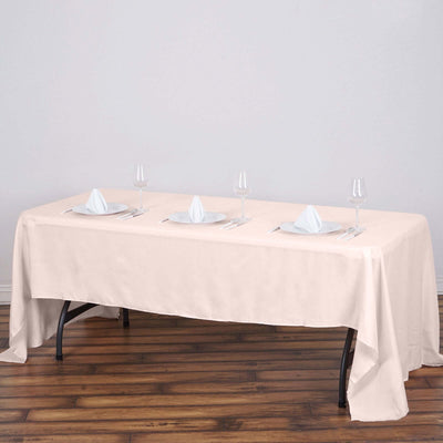 Elegant beige tablecloth draped over a dining table set for four.