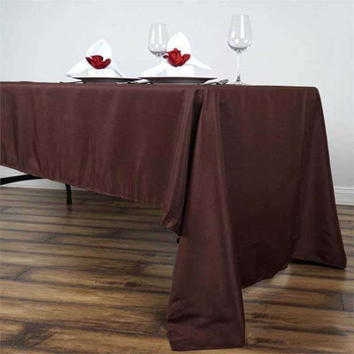 Brown tablecloth draping over a table set with glasses and napkins.