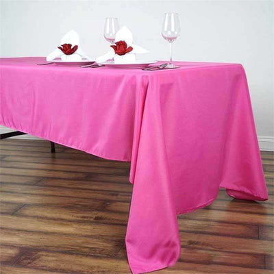Pink tablecloth draped elegantly on a dining table with decorative napkins and glasses.