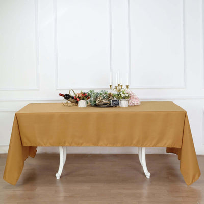 Table set with a gold tablecloth and decorative items for an elegant dining experience.