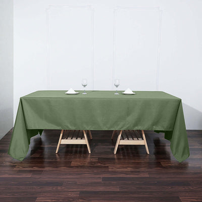 Green tablecloth draped over a table with glasses and napkins set for dining.