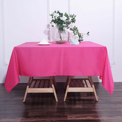 Pink tablecloth draped over a wooden table with decorative flowers.
