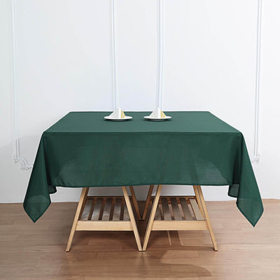Green tablecloth draped over a wooden table with candles.