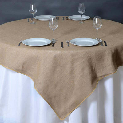 Burlap tablecloth on a round table set with plates and glasses.