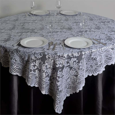 Lace tablecloth draped over a round table set for dining.