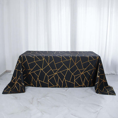 Black tablecloth with gold geometric pattern on a white backdrop.