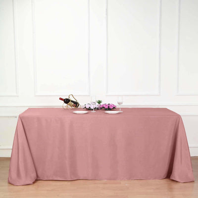 Pink tablecloth draped over a table in a styled dining setting.