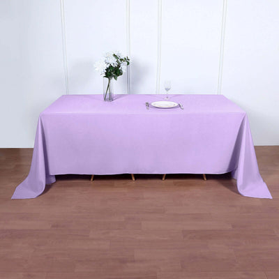 Lavender tablecloth draped over a table with a vase and plate on top