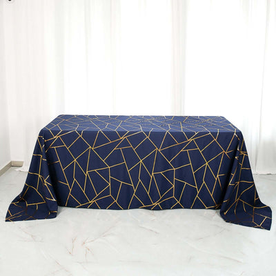 Decorative navy tablecloth with geometric gold pattern on a table.