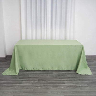Green tablecloth on a wooden floor with sheer curtains in the background.