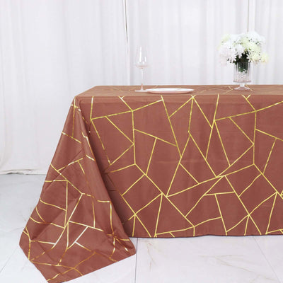 Brown geometric tablecloth with gold accents on a table.