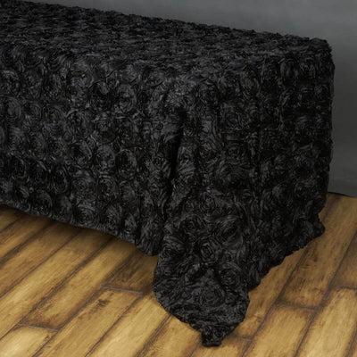 Black rose-patterned tablecloth on wooden surface.