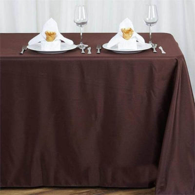 Brown tablecloth set with plates and napkins for dining.