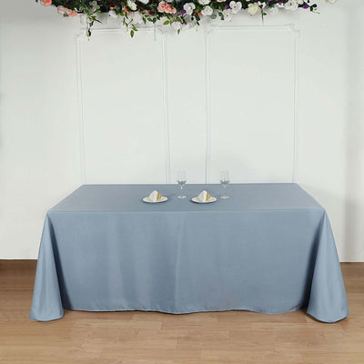 Elegant blue tablecloth draping a table set with plates and glasses.