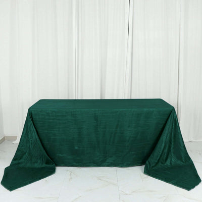 Green tablecloth draped over a table with elegant fabric texture.