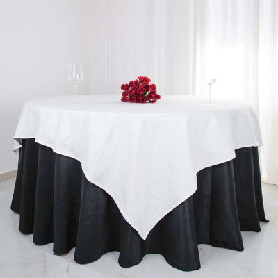Elegant round table with a white and black tablecloth, adorned with red roses.