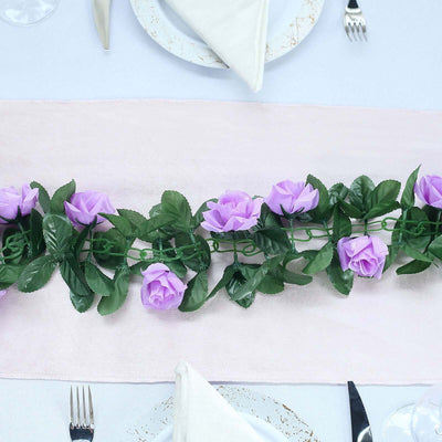 Purple rose garland on a dining table with white and pink decor.